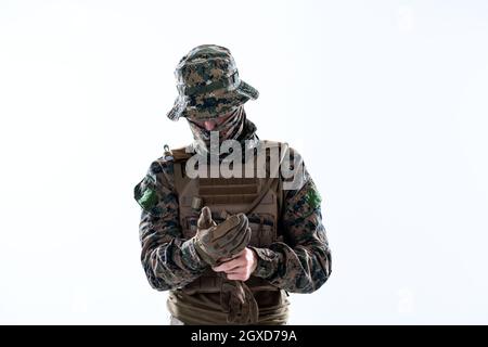 Primo piano di modern warfare soldato mettendo le mani protettive guanti battaglia sfondo bianco Foto Stock