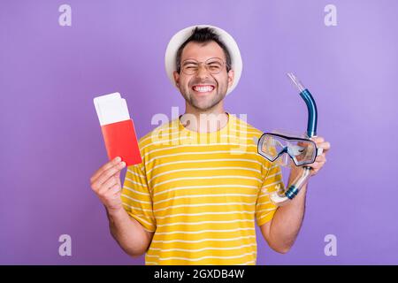 Foto di allegro felice pazzo positivo uomo tenere occhiali subacquei biglietti indossare occhiali isolati su sfondo di colore viola Foto Stock