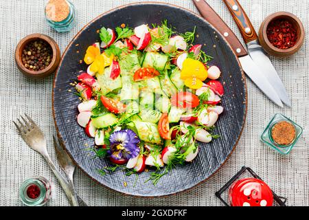 Insalata di primavera con verdure varie e fiori commestibili. Dieta food.Spring insalata di vitamina Foto Stock