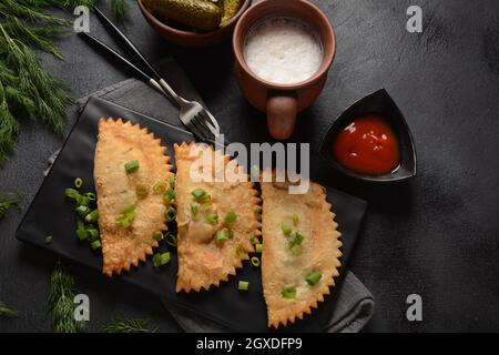 Cheburek con carne e cipolla primaverile Foto Stock