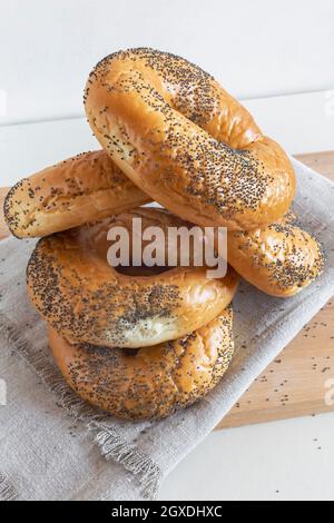 Alcuni deliziosi bagel con semi di papavero su un primo piano di tovagliolo. Vista frontale. Foto Stock