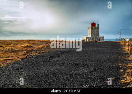 Faro di Dyrholaey al tramonto in una giornata nuvolosa, Islanda Foto Stock