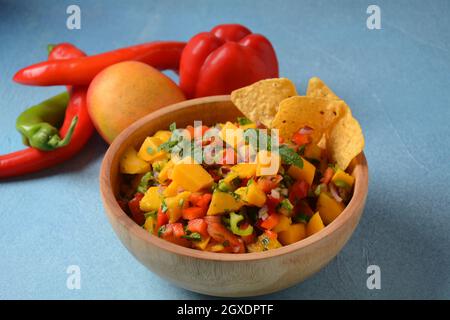 Salsa con mango, erbe, cipolle e peperoni, patatine di mais da vicino in una ciotola. Cibo messicano. Foto Stock