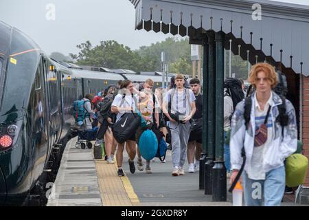 Giovani che arrivano alla stazione ferroviaria di Newquay per il giorno di apertura del festival Boardmasters in Cornovaglia. Foto Stock