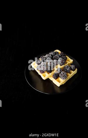 Cialde belghe con congelati more su uno sfondo nero. Foto Stock