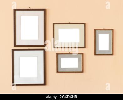 Set di varie cornici rettangolari mockup vuote di diverse dimensioni appese su pareti beige Foto Stock