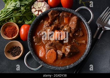 Manzo Bourguignon in una padella. Stufato con vino rosso, carote, cipolle, aglio, un bouquet garni, e guarnito con cipolle di perle, funghi e pancetta. Francese Foto Stock