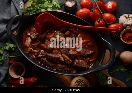 Manzo Bourguignon in una padella. Stufato con vino rosso, carote, cipolle, aglio, un bouquet garni, e guarnito con cipolle di perle, funghi e pancetta. Francese Foto Stock