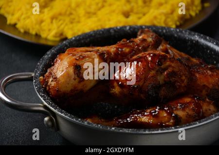 Pollo Tandoori con pasta di pollo fresca e spezie indiane croccanti e riso giallo selvatico cotto con curcuma turmerico spezie Foto Stock