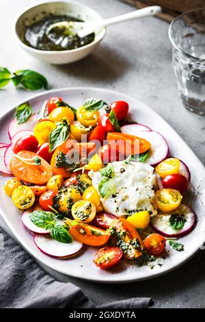 Burrata con colorati di pomodori ciliegini insalata con Pesto di fatti in casa Foto Stock