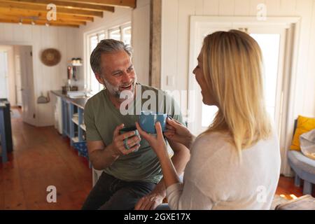 Felice coppia caucasica matura bere caffè nella cucina soleggiata Foto Stock