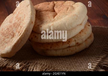 Una pila di pita pani. Pane pita su tavola di legno, pane arabo, pane piatto morbido al forno. Popolare cibo israeliano Foto Stock