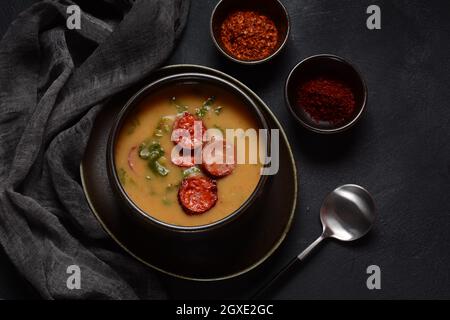 Zuppa di Caldo Verde con verdure e chorizo tritato sulla parte superiore della ciotola su sfondo scuro. Foto Stock