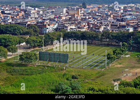 RIO DE JANEIRO, BRASILE - 7 GIUGNO 2014: Applicazione di erba sintetica su un campo di calcio in favela (Rio das Pedras) Foto Stock