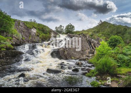 Cascata sul fiume Owenreagh, che attraversa il Molls Gap o la valle di MacGillycudys Reeks montagne, Wild Atlantic Way, Ring of Kerry, Irlanda Foto Stock