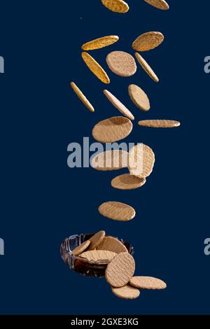 Deliziosi biscotti che cadono in un piccolo vaso di vetro Foto Stock