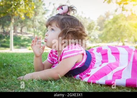Carino Bambina godendo della sua Lollipop all'esterno. Foto Stock