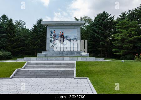 Pyongyang, Corea del Nord - 27 luglio 2014: Banner propagandistico raffigurante una scena d'infanzia di Kim il Sung nel Parco di Mangyongdae Foto Stock