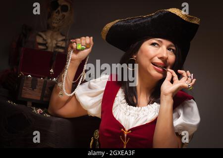 Drammatica pirata femminile di mordere una moneta in un ambiente poco illuminato Moody scena. Foto Stock