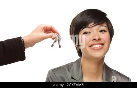 Razza mista giovane donna che viene consegnata chiavi isolate su uno sfondo bianco. Foto Stock