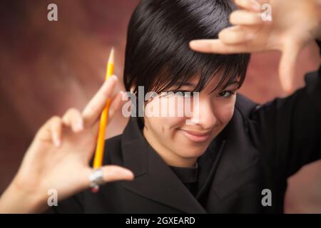 Bella ragazza multietnica pone per il suo ritratto facendo un telaio con le mani. Foto Stock