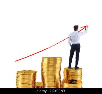 L'uomo d'affari disegna la freccia rossa crescente delle statistiche dell'azienda sopra un mucchio di soldi Foto Stock