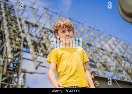 Un ragazzino sta studiando attrezzature militari. Nessuna guerra Foto Stock