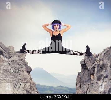 Il ballerino clown si divide tra due montagne Foto Stock