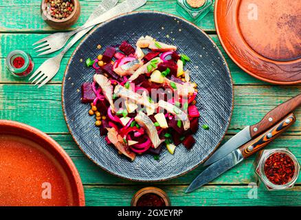 Insalata con aringhe, barbabietole, cipolle e piselli verdi. Cibo tedesco Foto Stock