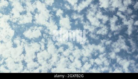 Piccole nuvole ariose su cielo blu Foto Stock