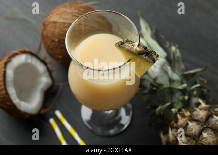 Cocktail Pina colada e ingredienti su tavola di legno scuro. Foto Stock