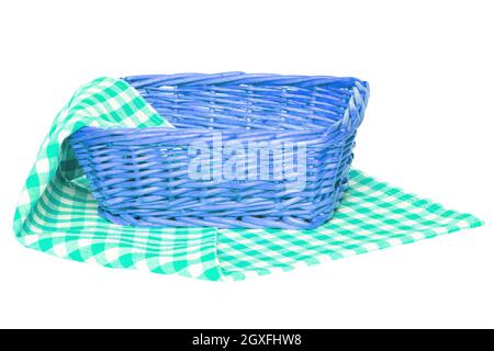 Cestino da picnic vuoto. Closeup di un cesto di vimini vuoto su un tovagliolo bianco verde, coperta o tovagliolo isolato su uno sfondo bianco. Per te Foto Stock