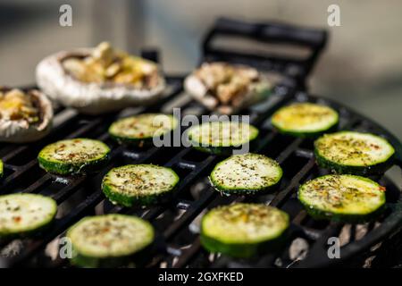 carne di vitello, salmone e zucchine su griglia da giardino con carbone Foto Stock