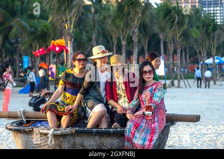 Gruppo di donne che siedono in una barca a cestino rotonda a China Beach, da nang, vietnam. Spiaggia di My Khe Foto Stock