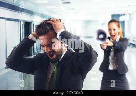 Boss spolds con megaphone un dipendente disperato Foto Stock