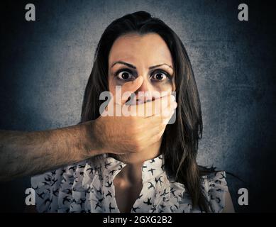 Mano che copre la bocca di una ragazza ferita e spaventata Foto Stock