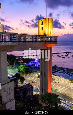 Facciata del famoso ascensore Lacerda illuminata di notte della città di Salvador in Bahia con il mare sullo sfondo Foto Stock