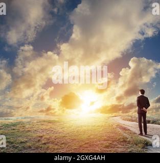 L'uomo d'affari guarda lontano durante l'alba. Il concetto di opportunità di business future e nuove Foto Stock