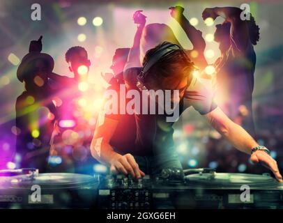 DJ al lavoro suonando musica con un mixer alla discoteca. Doppia esposizione Foto Stock