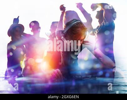 DJ al lavoro suonando musica con un mixer alla discoteca. Doppia esposizione Foto Stock