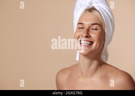 Ritratto di una donna felice con le freckles avvolse i suoi capelli con un tovagliolo bianco Foto Stock