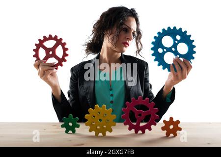 Businesswoman cerca di lavorare con il sistema di ingranaggi. Concetto di lavoro di squadra e partnership. Isolato su sfondo bianco Foto Stock
