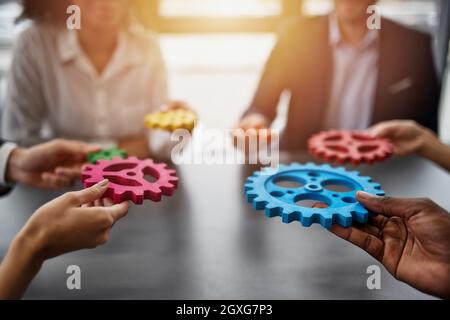 Il lavoro di squadra di operatori lavorano insieme e unire pezzi di ingranaggi. Accordo di partenariato e di concetto di integrazione Foto Stock