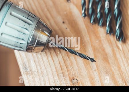 Primo piano del perforatore che giace su una tavola di legno Foto Stock