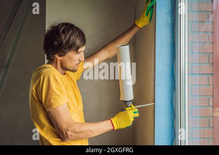 Builder o handyman è impegnato nella riparazione o installazione di finestre Foto Stock