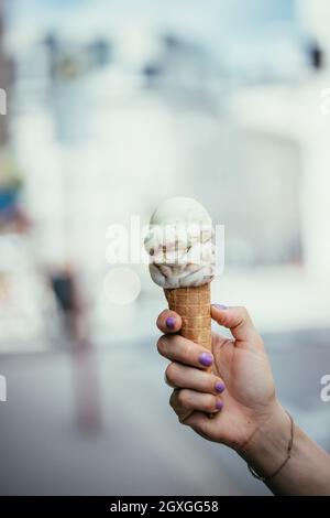 La donna trattiene il ghiaccio in mano, bella giornata d'estate Foto Stock