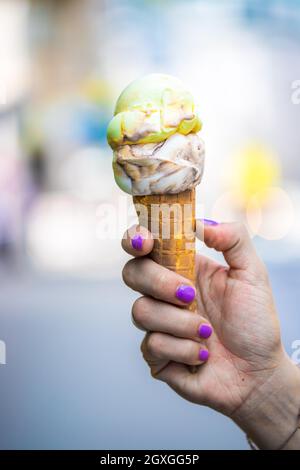 La donna trattiene il ghiaccio in mano, bella giornata d'estate Foto Stock