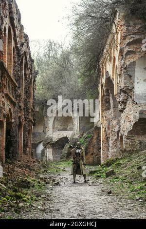 Post-apocalisse nucleare. Unico sopravvissuto in tatters e maschera a gas sulle rovine della città distrutta Foto Stock