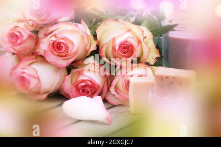 Rose fragranti con regalo di giorno delle madri per il benessere. Rose rosa con bokeh tenero su legno grigio. Sfondo con breve profondità di campo per il gre del giorno delle madri Foto Stock