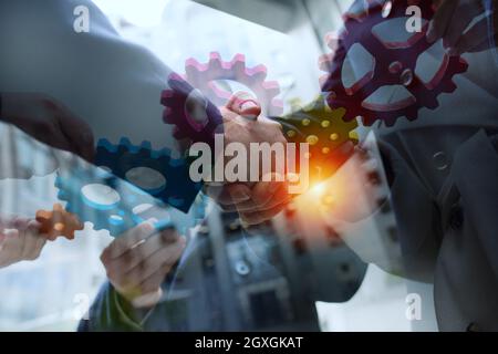 Il lavoro di squadra di operatori lavorano insieme e unire pezzi di ingranaggi. Accordo di partenariato e di concetto di integrazione Foto Stock